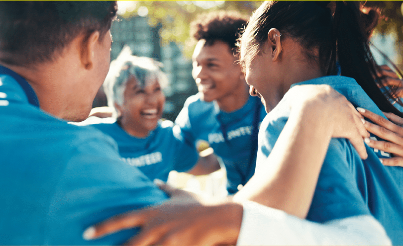 Volunteer, people or group in circle outdoor for synergy, collaboration or donation. Charity, team or huddle together for support, excited or hands for community service in cooperation for motivation