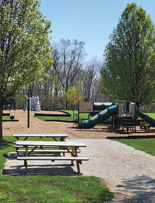 A park with a playground and picnic tables. Description generated by AI