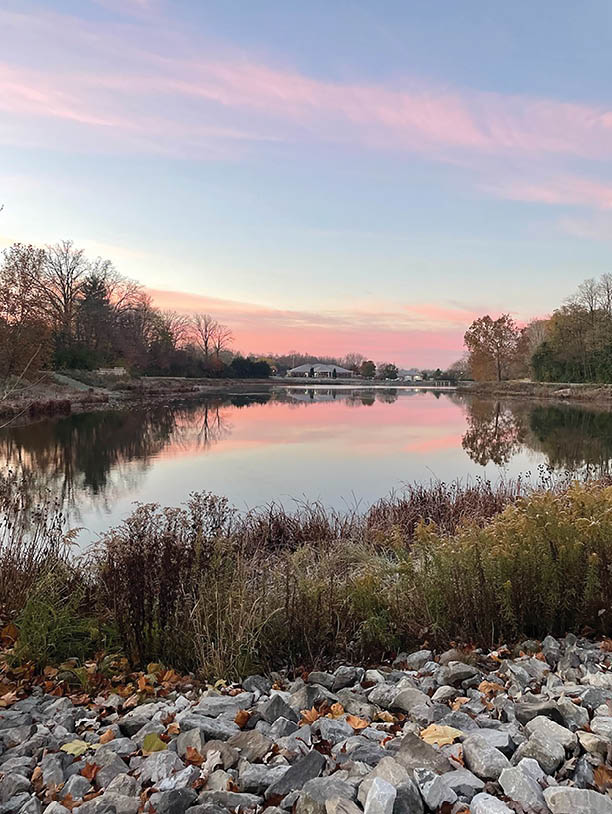 A body of water with a pink sky in the background. Description generated by AI