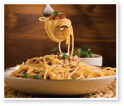 Delicious spaghetti with bacon and egg called alla carbonara on wooden table