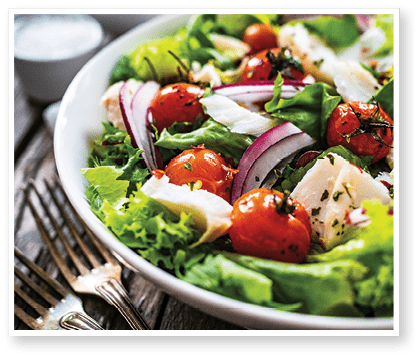 Roast cod and vegetable salad on wooden background