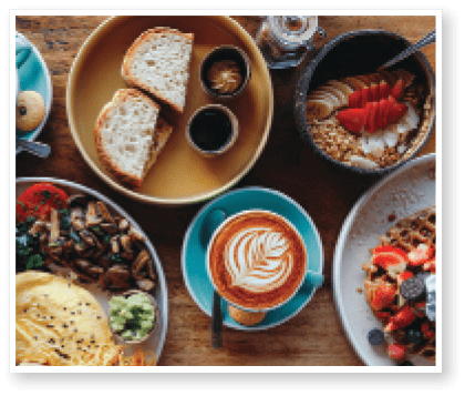 Morning breakfast on a table above, waffles with cream, berries, coffee, cappuccino, bowl, omlet with vegetables, bread with butter, avocado cream, vegan food, healthy food, meal.
