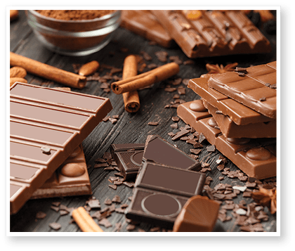 Whole and broken chocolate, chocolate bars, candies, chocolate chips on a dark wooden background