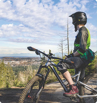 A mountain biker soaking up the view of Bellingham while climbing up Galbraith Mountain.