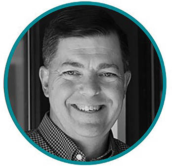 A man wearing a plaid shirt smiling. Description generated by AI