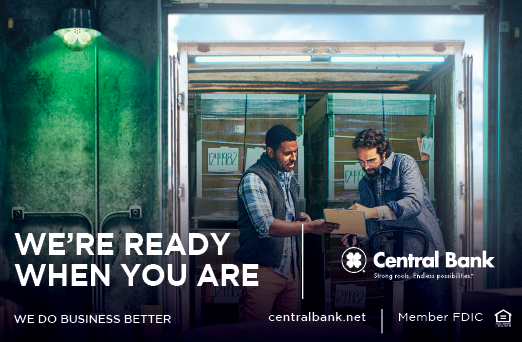 Two men are standing in front of a door, one of them is holding a box. AI generated content
