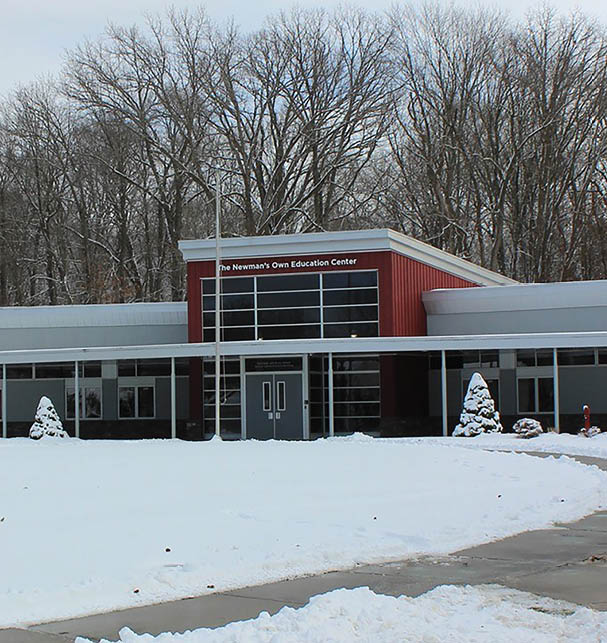 A large building with a red roof and white walls is surrounded by snow. AI generated content