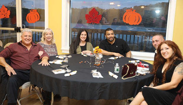 A group of people are sitting around a table with a black tablecloth. AI generated content