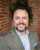 A man wearing a suit and tie is smiling for the camera. AI generated content