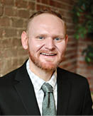 A man wearing a suit and tie is smiling for the camera. AI generated content
