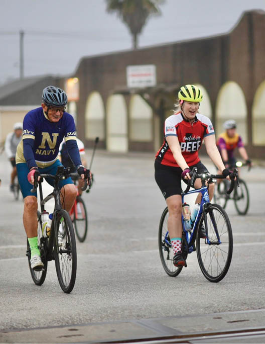 A group of bicyclists riding down a street, some wearing helmets. AI generated content
