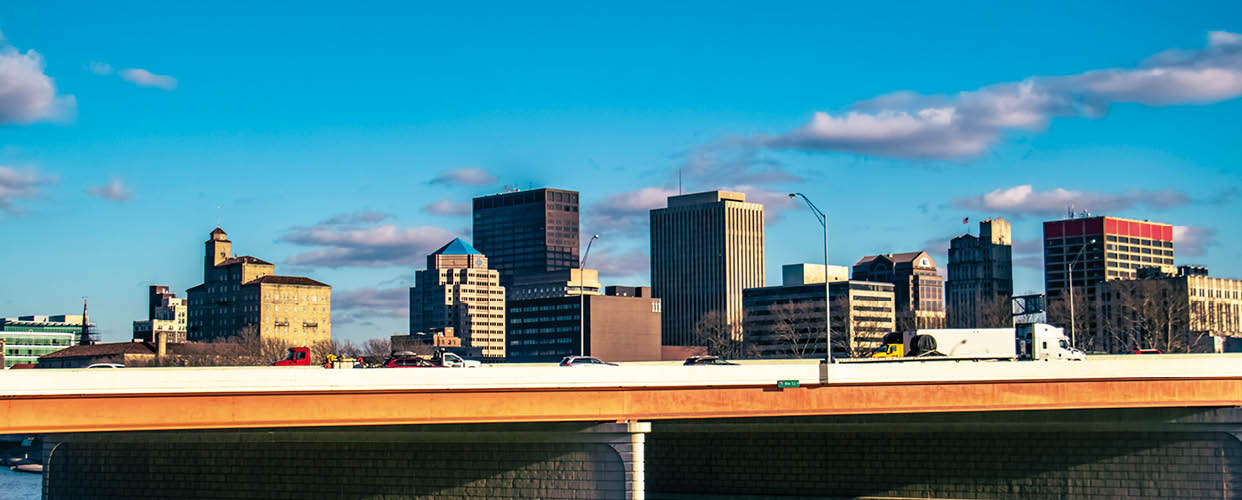 Photograph of the skyline of Dayton, OH with the Miami River and Interstate 75 in the foreground.