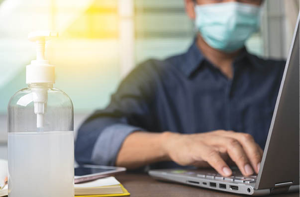 Alcohol gel with male employee wearing a health mask Preventing corona virus infection covid-19 in back, concept of working from home and social distancing 