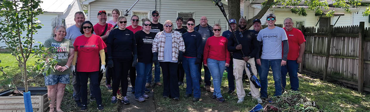 A group of people are standing in a yard in front of a house. AI generated content