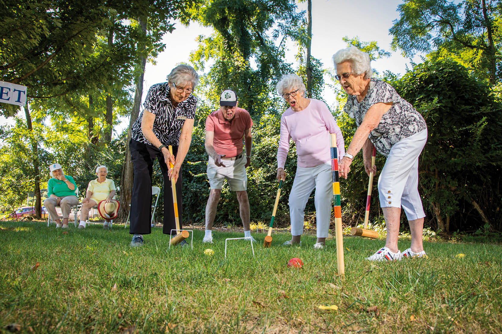 Four older women are playing croquet in a park. AI generated content