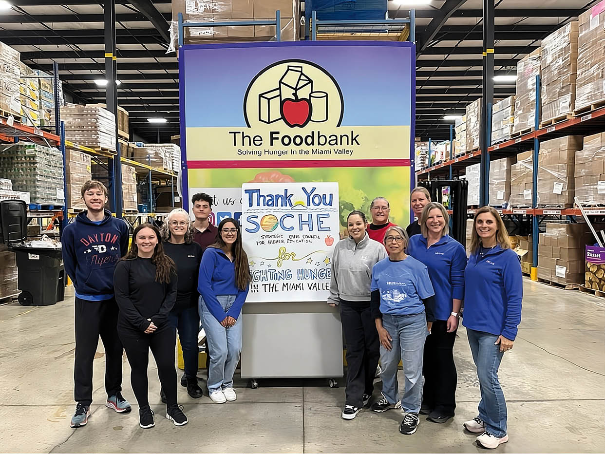 A group of people pose for a photo in front of a large sign that says “The Foodbank". AI generated content
