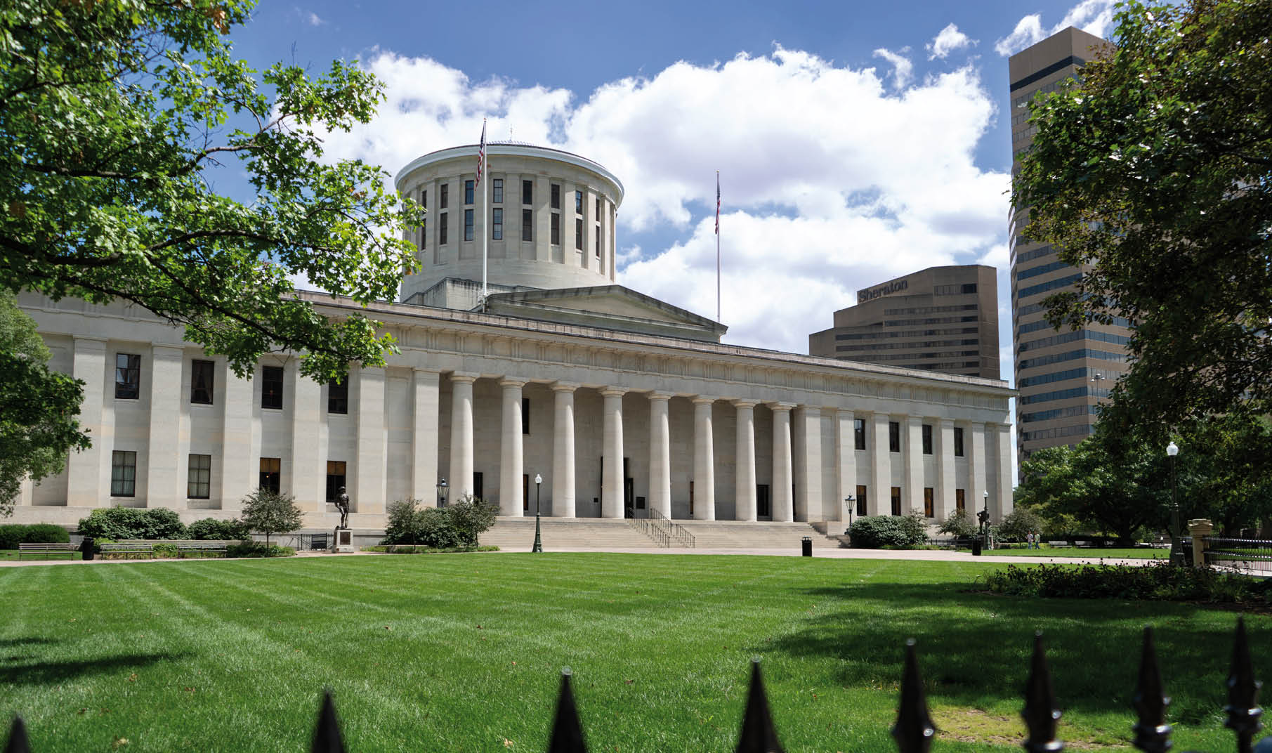 The Ohio Statehouse and accompanying park, located in Columbus, Ohio. Pictured on a bright, sunny day.