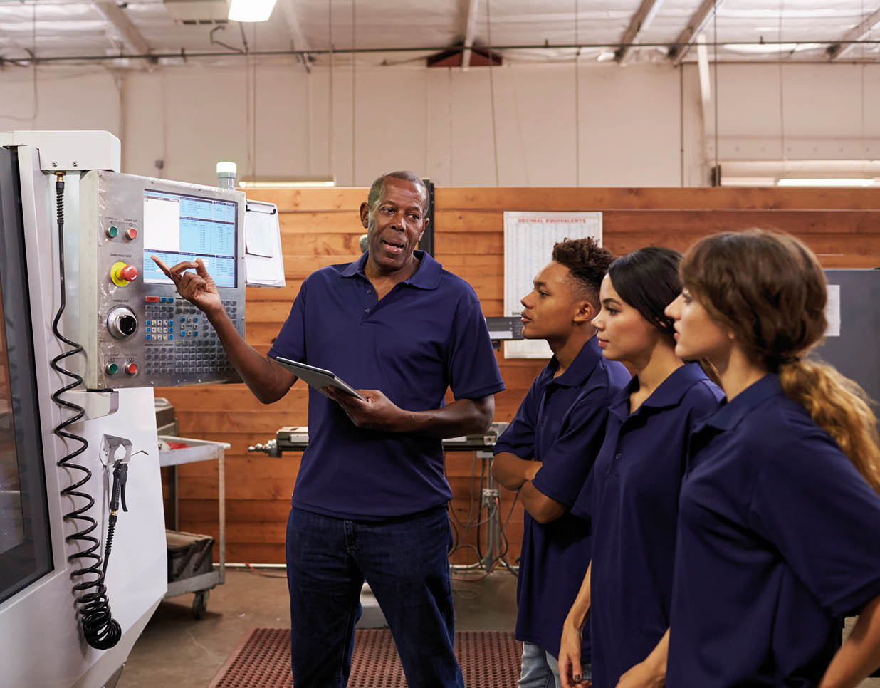 Engineer Training Apprentices On CNC Machine