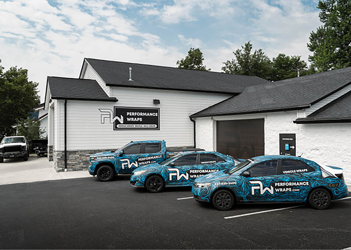 Three cars are parked in front of a white building. Description generated by AI
