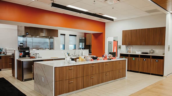 A kitchen with a marble counter top and wooden cabinets. Description generated by AI