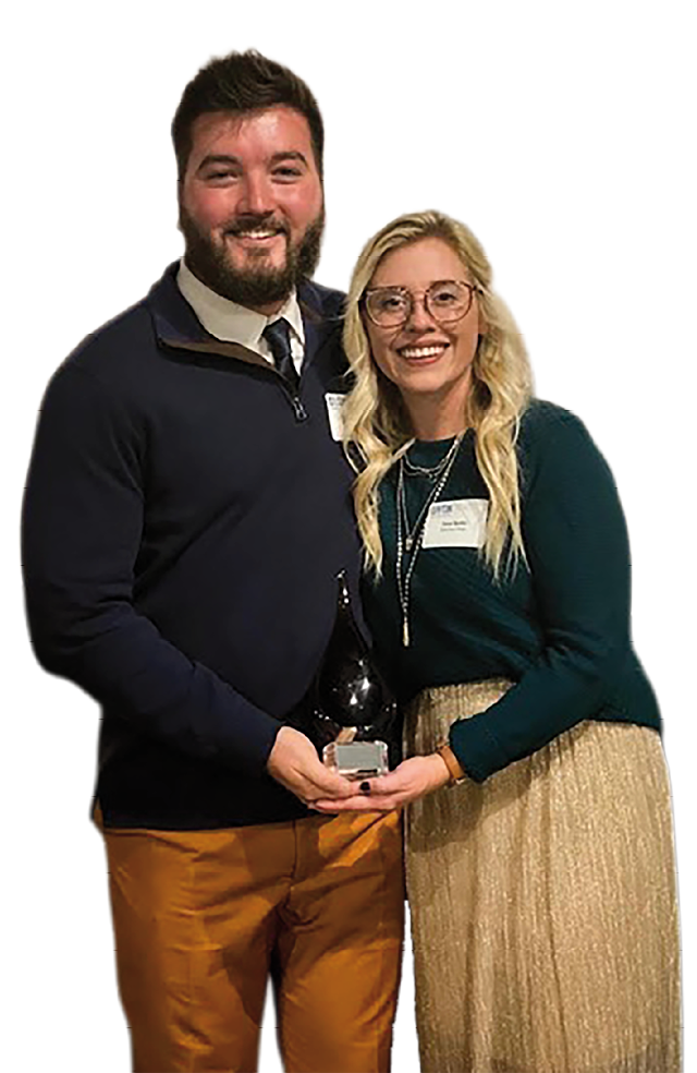 A man and woman are holding a trophy together. Description generated by AI