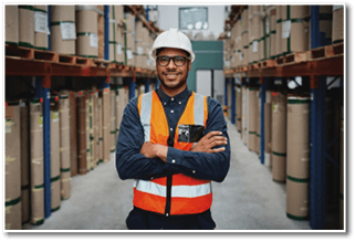 Happy manager in warehouse standing looking at camera with folded hands in a factory