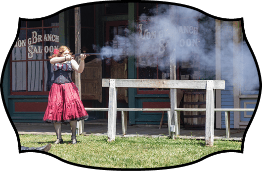 A man and woman are reenacting a scene from the Wild West, with the woman holding a gun and the man lying on the ground. AI generated content