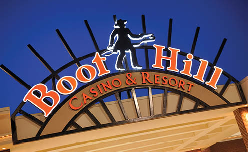 A sign for Boots Hill Casino & Resort is lit up at night. AI generated content