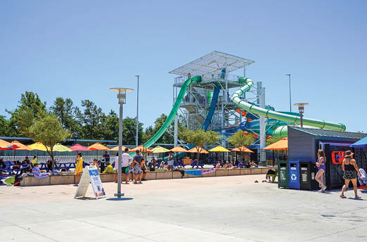 A large water slide is in a water park with many people around it. AI generated content