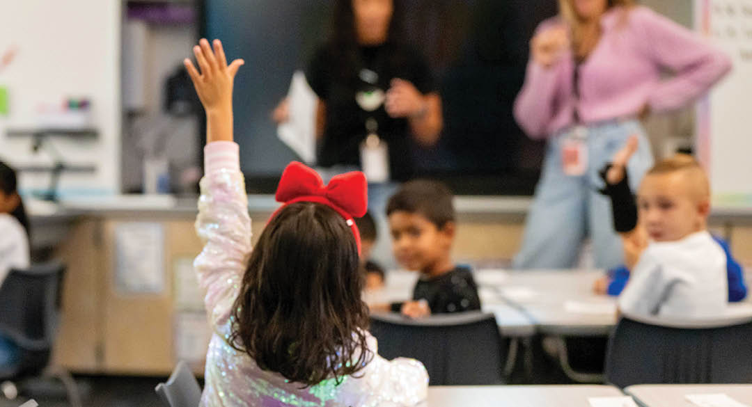 A young girl is raising her hand in a classroom setting. AI generated content