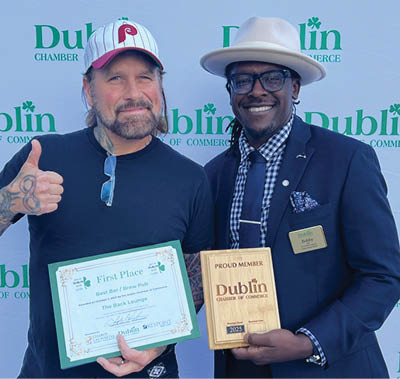 Two men are standing on a stage, one holding a certificate and the other holding a box. AI generated content