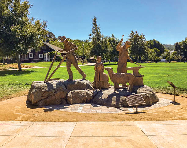 A statue of a man and woman is located in a park. AI generated content