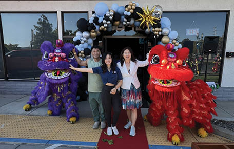 Three people pose with two large red and gold dragon statues. AI generated content