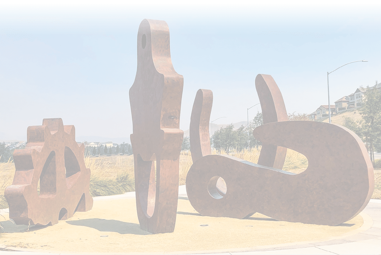 A group of sculptures are displayed on a sidewalk, including a large metal sculpture of a wrench. AI generated content