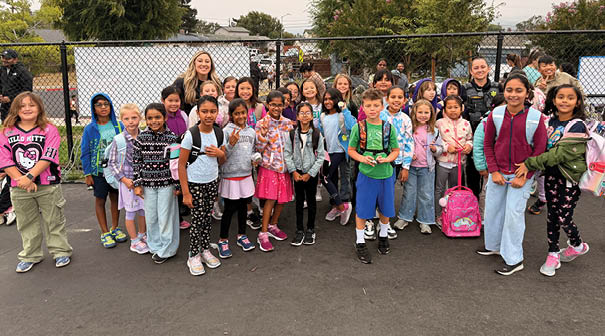 A group of children posing for a picture in front of a fence. AI generated content