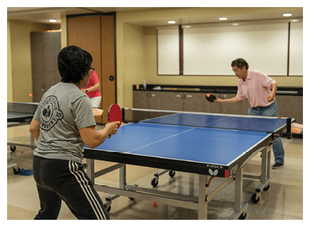 Two people playing ping pong in a room. AI generated content