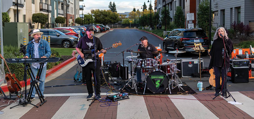 A group of four people are playing musical instruments on a street corner. AI generated content