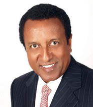A man wearing a suit and tie smiling. Description generated by AI