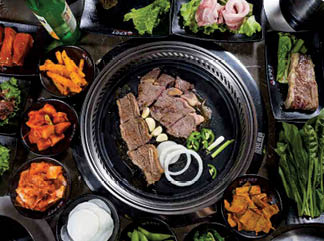 A tray of food with a variety of items including meat, vegetables, and sauces. Description generated by AI