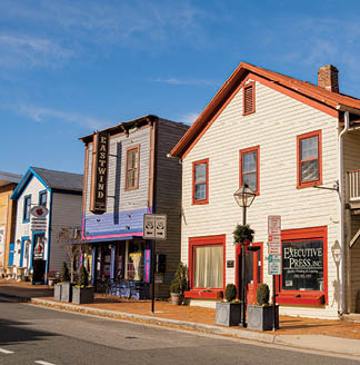A street with a red and white building with a black lamp post. Description generated by AI