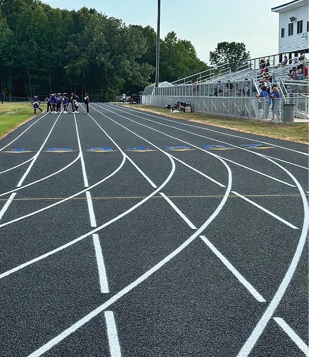 A group of people are standing on a track, with some sitting on the sidelines. AI generated content