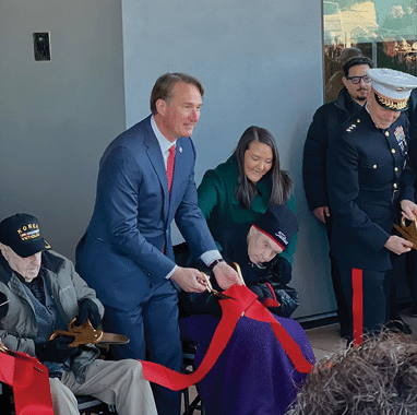 A man in a suit is cutting a red ribbon with scissors. AI generated content