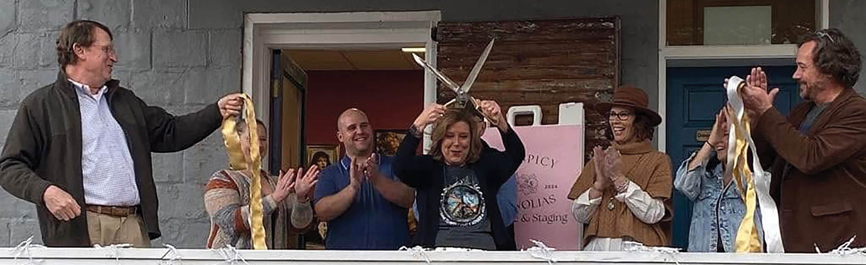 A group of people are gathered on a porch, some holding up their hands. A man is holding a sword, and a woman is holding a fish. The people are clapping and celebrating. AI generated content