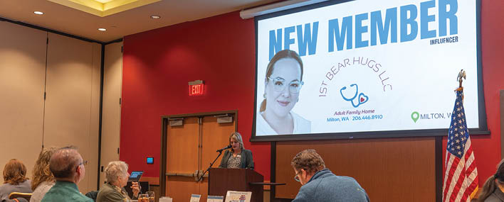 A large screen with a woman on it. Description generated by AI