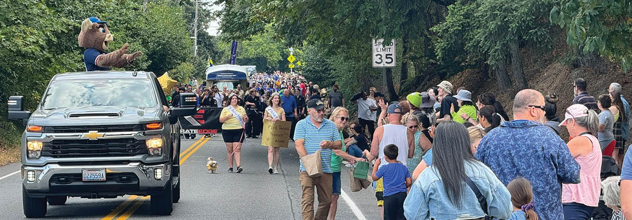 A parade is taking place on a street with a large crowd of people. Description generated by AI