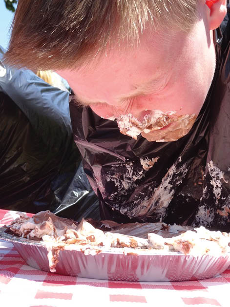 A boy eating a cake with his face covered in frosting. Description generated by AI