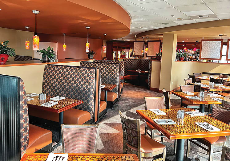 A restaurant with a dining room and a bar. Description generated by AI