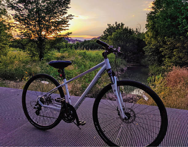 A bicycle is parked on a bridge over a river. AI generated content