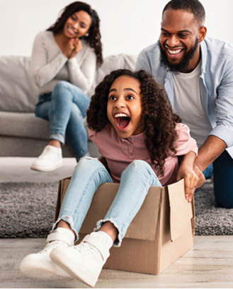 A family of three is sitting on a box, with a man and a woman sitting on top of the box and a child sitting on the man's lap. They are all smiling and appear to be enjoying the moment. AI generated content