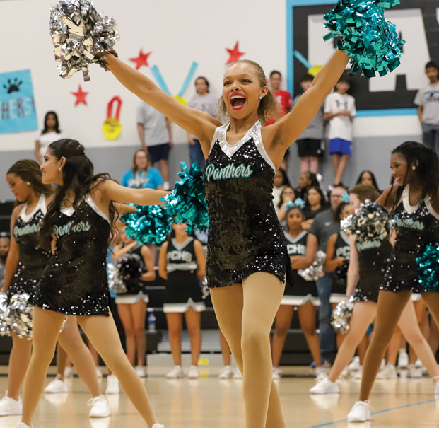 A cheerleader is performing in front of a crowd of people. AI generated content